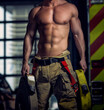 Sexy firefighter body holding fire hoses