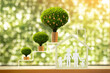 © Watchara - Stacking gold coins and money bag of tree with growing value and family in the home model ​in the public park, Saving or investment for buy a real estate and house concept.