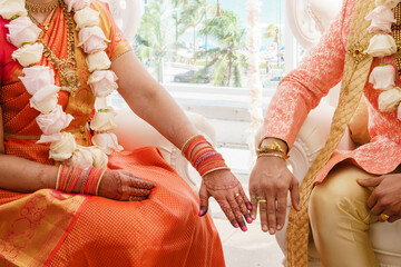 Wall Mural - Indian Bride in orange dress and Groom in orange costume showing their rings Closeup Hindu Wedding Concept Bride and Groom Wedding clothes Traditional Indian Wedding Close up Cropped photo