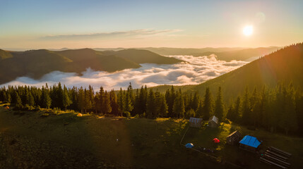 Wall Mural - Aerial view of tourist camping tents on mountain campsite at bright sunny evening. Active tourism and hiking concept