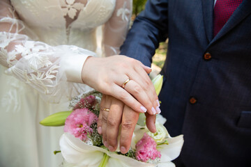 Wall Mural - A pair of gold rings for wedding ceremony on bride and groom hands