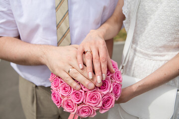 Wall Mural - A pair of gold rings for wedding ceremony on bride and groom hands