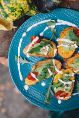 Sticker - A top view of french toasts with avocado spread and tomatoes on a blue plate