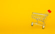 Metal basket for groceries from the supermarket on a yellow background. The concept of online trading, online shopping, delivery of goods with place for text and copy space. good quality photo