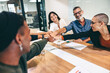 © Jacob Lund - Successful businesspeople bringing their fists together in a boardroom