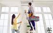© Studio Romantic - Technician repairing AC on his typical working day. Man climbs ladder with toolbox in order to check, do disinfection or fix troubles in modern white wall mounted air conditioner in young lady's home