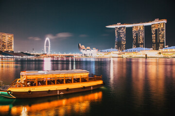 Wall Mural - SINGAPORE, SINGAPORE - MARCH 2019: Skyline of Singapore Marina Bay at night with Marina Bay sands, Art Science museum , skyscrapers and tourist boats