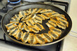 fish is about to fry in the pan, crispy fried fish, anchovy fish is cooking in the pan,