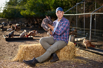 Adult man hold rabbit at farm. A portrait is outside. Taking care of pets.