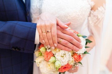 Wall Mural - A pair of gold rings for wedding ceremony on bride and groom hands