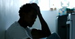 Worried African american man sitting on home floor feeling despair, frustration, suffering from mental illness