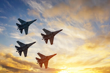four fighter jets in the shape of a diamond in the sky beautiful sunset.