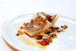 sea bass fillet with skin in olive oil and tomato and spices on a plate on a white background