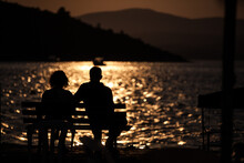 Romantic Couple Watching The Sea At Sunset