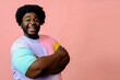 © Carlos David - young happy smiling black african american arms crossed man posing in the studio over pink background