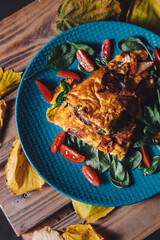 Sticker - A vertical shot of an omelette with bacon and vegetables on a blue plate