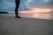 © christophe papke - Frau steht in Sportkleidung am Strand