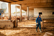© Cavan Images - Young farmer boy opening the calf barn to clean it