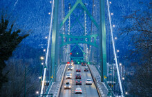 Closeup View Of Lions Gate Suspension Bridge In Vancouver, British Columbia, Canada At Night In Winter Full Of Lights
