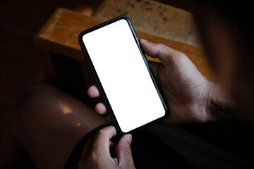 Wall Mural - close up view young man hands holding smart phone empty screen while sitting at workplace.