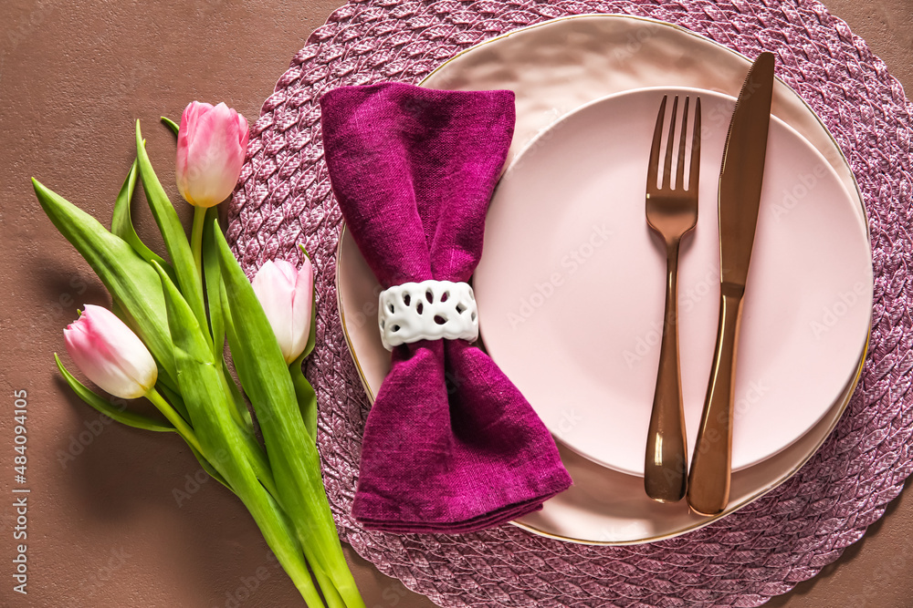 Stylish table setting with tulip flowers on brown background