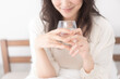 © lielos - ベッドで水を飲む女性
