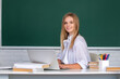 © Volodymyr - Successful female student at classroom of university. Portrait of young female college student studying in classroom on class with blackboard background.