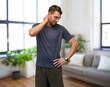 © Syda Productions - fitness, sport and healthy lifestyle concept - man with smart watch or tracker holding to aching neck over home room background