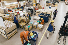 Male And Female Blue-collar Workers In Uniform Working In Factory Warehouse