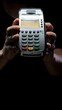 © Diflope - Credit card reader isolated on black background. Pos apparatus for non-cash contactless payment. A man holds an NFC terminal in his hands.