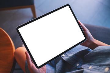 Mockup image of a woman holding digital tablet with blank white desktop screen in cafe