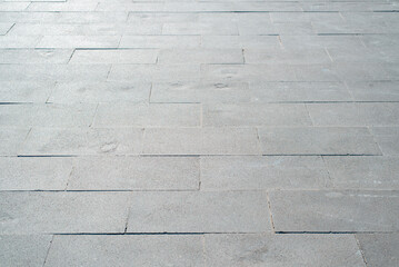 Gray wide paving slabs, stone tile path, close-up of paved city square on sunny summer day outdoors. Perspective view