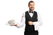 Male server holding a plate with stacks of money