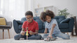 © Synthex - Curious little boy playing with a doll and his sister playing with a toy car, gender stereotypes in toys