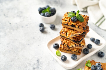 Sticker - Shortbread bar cookies with blueberries on a serving plate on a light gray kitchen table. Delicious homemade sweet pastries