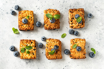 Wall Mural - Shortbread bar cookies with blueberries are spread out  on a light gray kitchen table. Delicious homemade sweet pastries	