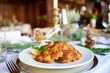 Sehr leckeres Wiener Schnitzel mit Krosser Panade und Bratkartoffeln und Preiselbeer serviert in einem Restaurant Wirtshaus