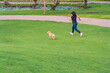 © Quang - Young woman jogging with her golden puppy in the park