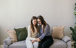 © Яна Айбазова - Psychological assistance to women. Domestic violence. Two women are sitting on the couch and hugging. Supportive hugs