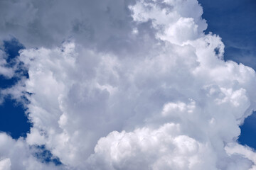 Bright landscape of white puffy cumulus clouds on blue clear sky