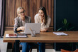 © Ilona - Two coworkers women in the office work and discuss an idea for a business at a briefing.