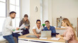 © Studio Romantic - Group of students studying in the classroom or campus library. Happy, smiling college or university students gather together, use modern laptop computers, discuss their homework and future projects