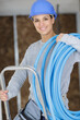© auremar - female builder on stepladder holding blue pipe