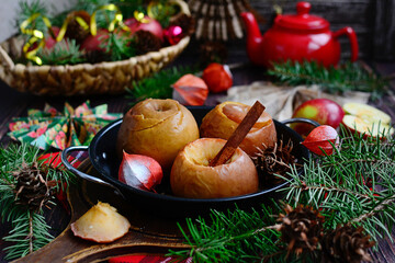 Wall Mural - Baked apples with cinnamon sticks on a Christmas background. Sweet and healthy dessert