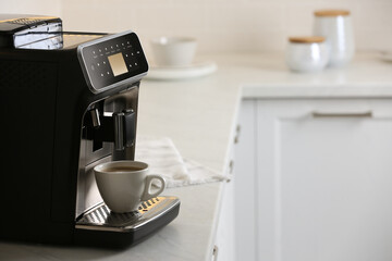 Canvas Print - Modern electric espresso machine with cup of coffee on white marble countertop in kitchen