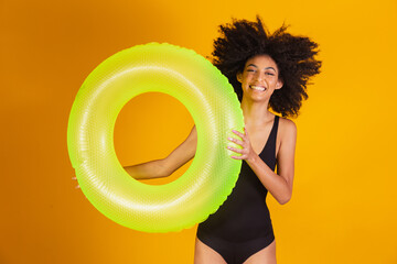 Wall Mural - afro woman with a floating buoy on yellow background