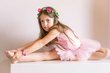 Young girl dancing classical ballet with her favourite pink tutu preparing for her lesson while waiting for the teacher.