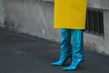 Fototapeta Londyn - woman wearing neon blue high heel boots and yellow coat