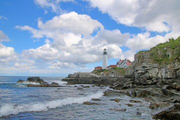 Wall Mural - A serene view of a lighthouse on the shore of the ocean in Portland