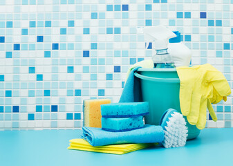 Cleaners and detergents in bucket, accessories for cleaning various surfaces and rooms blue background